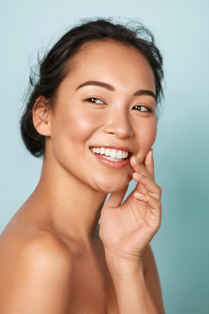 Femme qui sourit en se touchant le visage